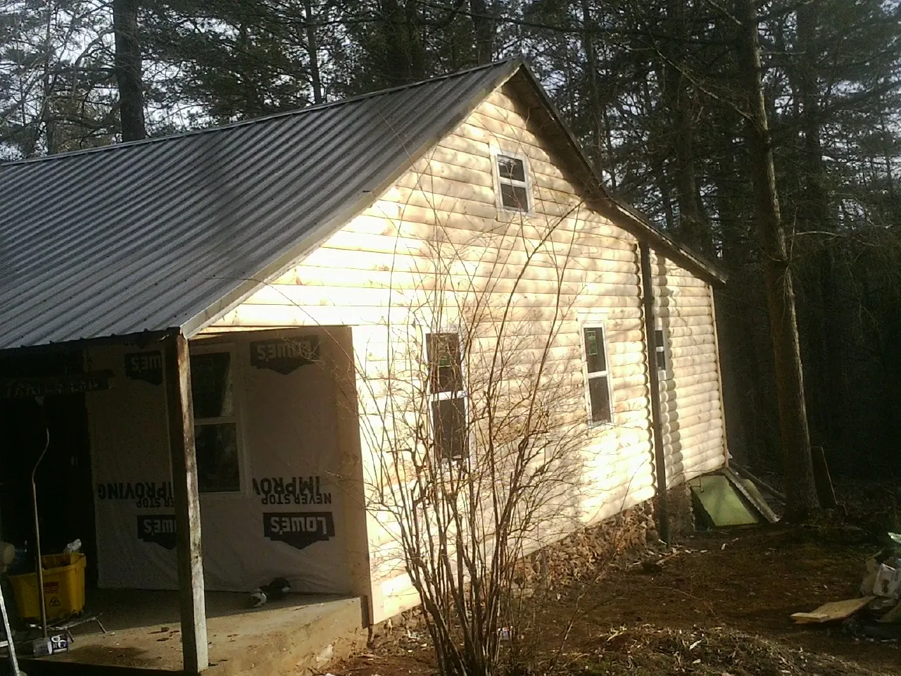 Log siding gable end under a dark metal roof edge in Verona